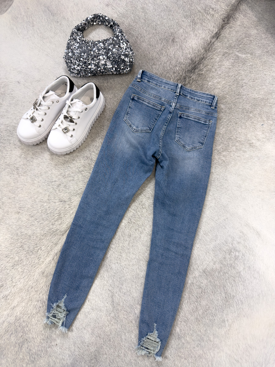 IMG_7128-2 Spodnie jeansowe skinny Malibu – dopasowane niebieskie jeansy damskie z przetarciami i surowym wykończeniem nogawek, stylizacja z T-shirtem i sneakersami.