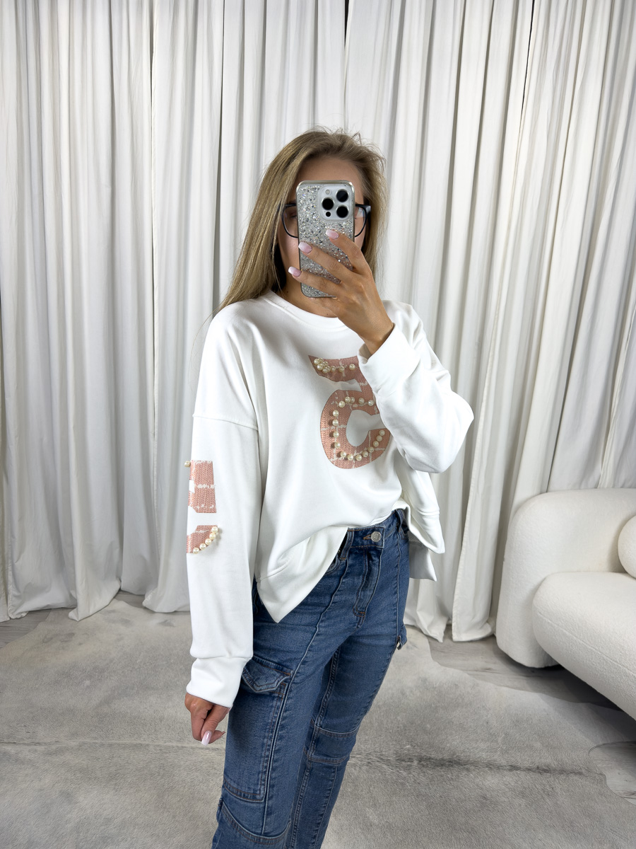 IMG_2611 Modelka w białej bluzie z perełkami White, jeansach skinny i białych sneakersach – stylizacja casual z eleganckim akcentem.