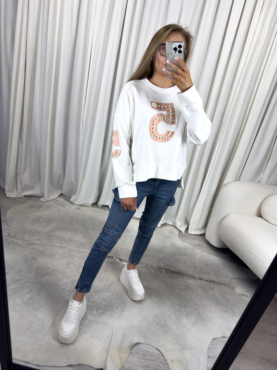 IMG_2620 Modelka w białej bluzie z perełkami White, jeansach skinny i białych sneakersach – stylizacja casual z eleganckim akcentem.