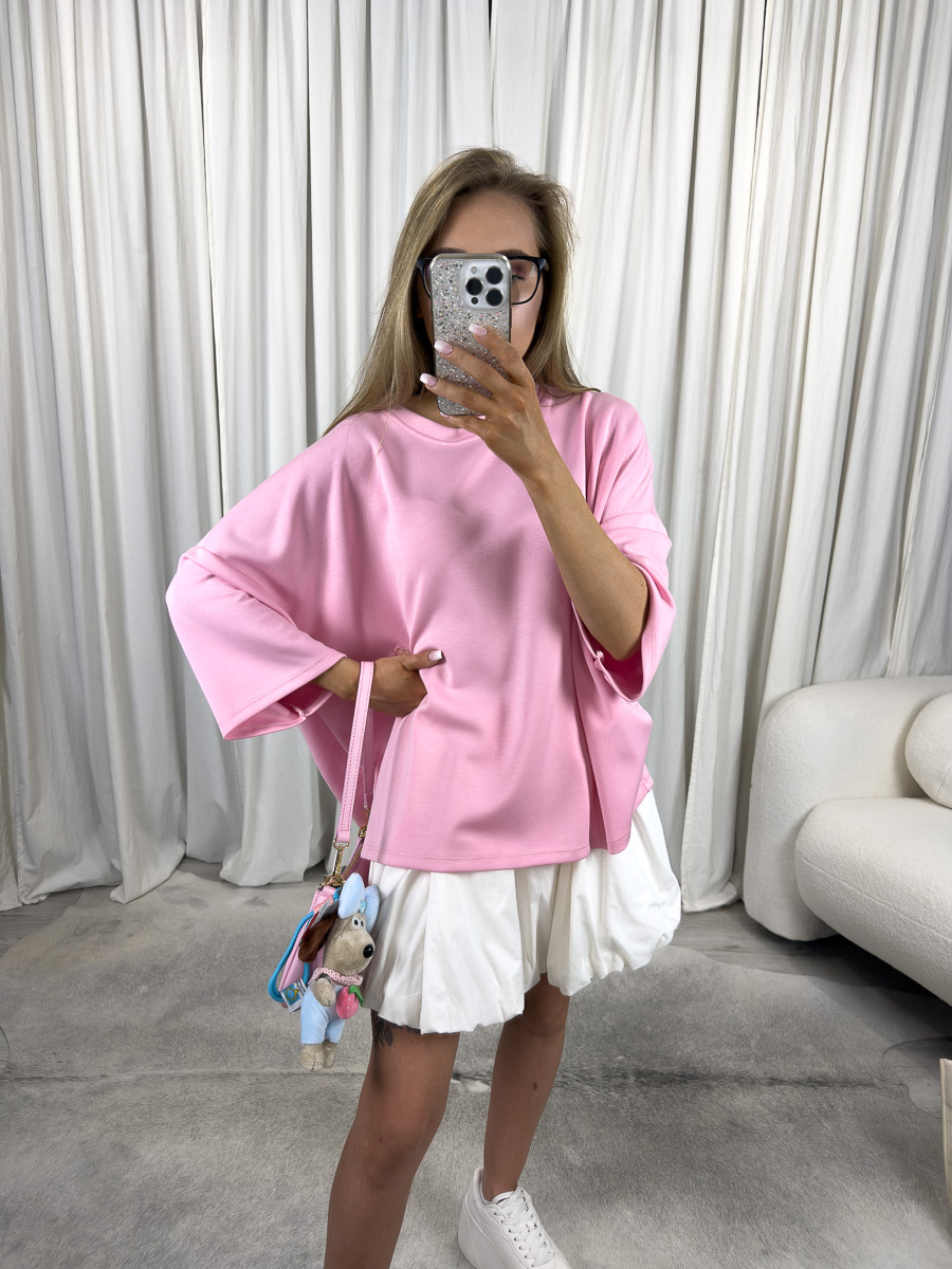 IMG_2931 Modelka w różowym t-shircie oversize Silky, zestawionym z białą spódnicą i pastelową torebką – stylizacja casualowa w stylu soft girl.
