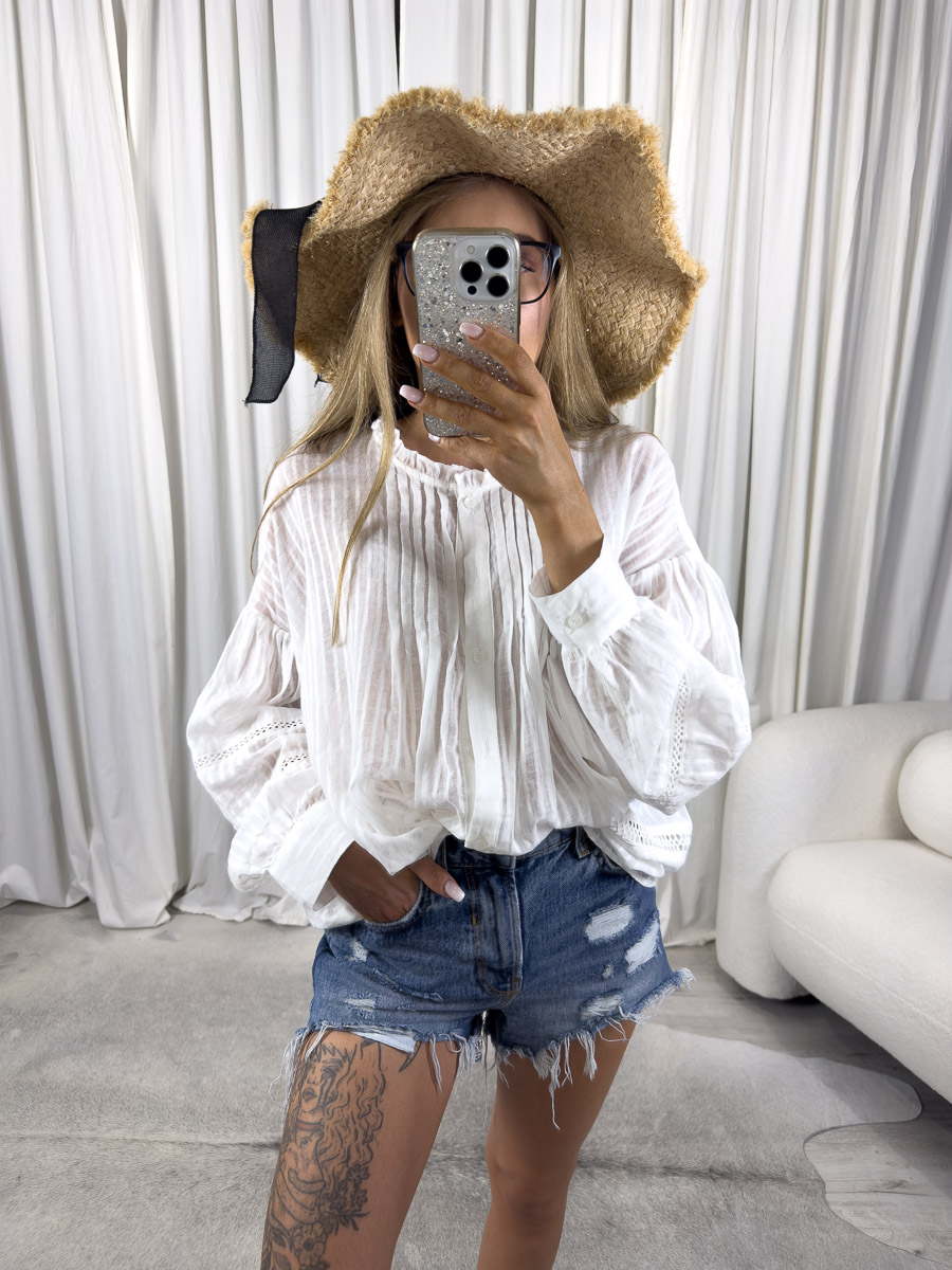 koszula-w-stylu-boho-luna-wiya Zdjęcie produktowe sklepu internetowego z odzieżą damską – modelka w koszuli boho Luna marki Wiya, zestawionej z jeansowymi szortami, kapeluszem i wiklinową torbą