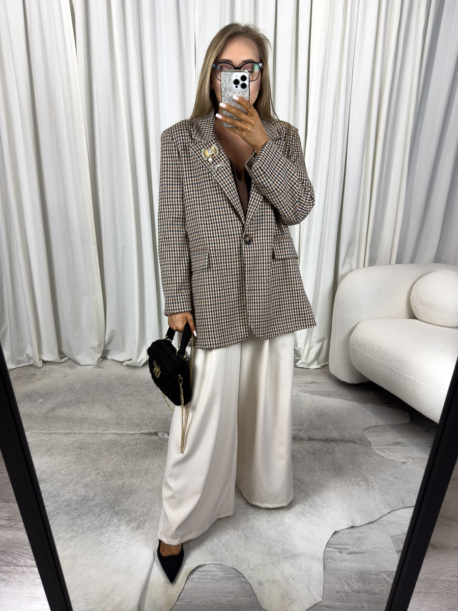 marynarka-o-prostym-kroju-glam-brazowa Modelka w marynarce o prostym kroju Glam z broszką i szerokimi spodniami. Zdjęcie produktowego sklepu internetowego z odzieżą damską.