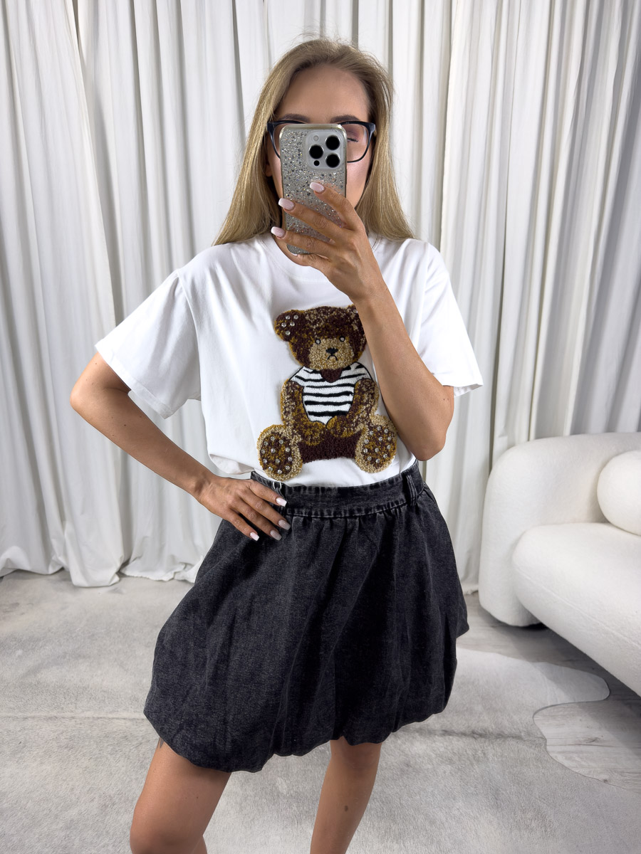 t-shirt-teddy-bialy Zdjęcie produktowe sklepu internetowego z odzieżą damską – modelka w trampkach ubrana w t-shirt Teddy biały, spódnicę w kolorze dekatyzowanej czerni