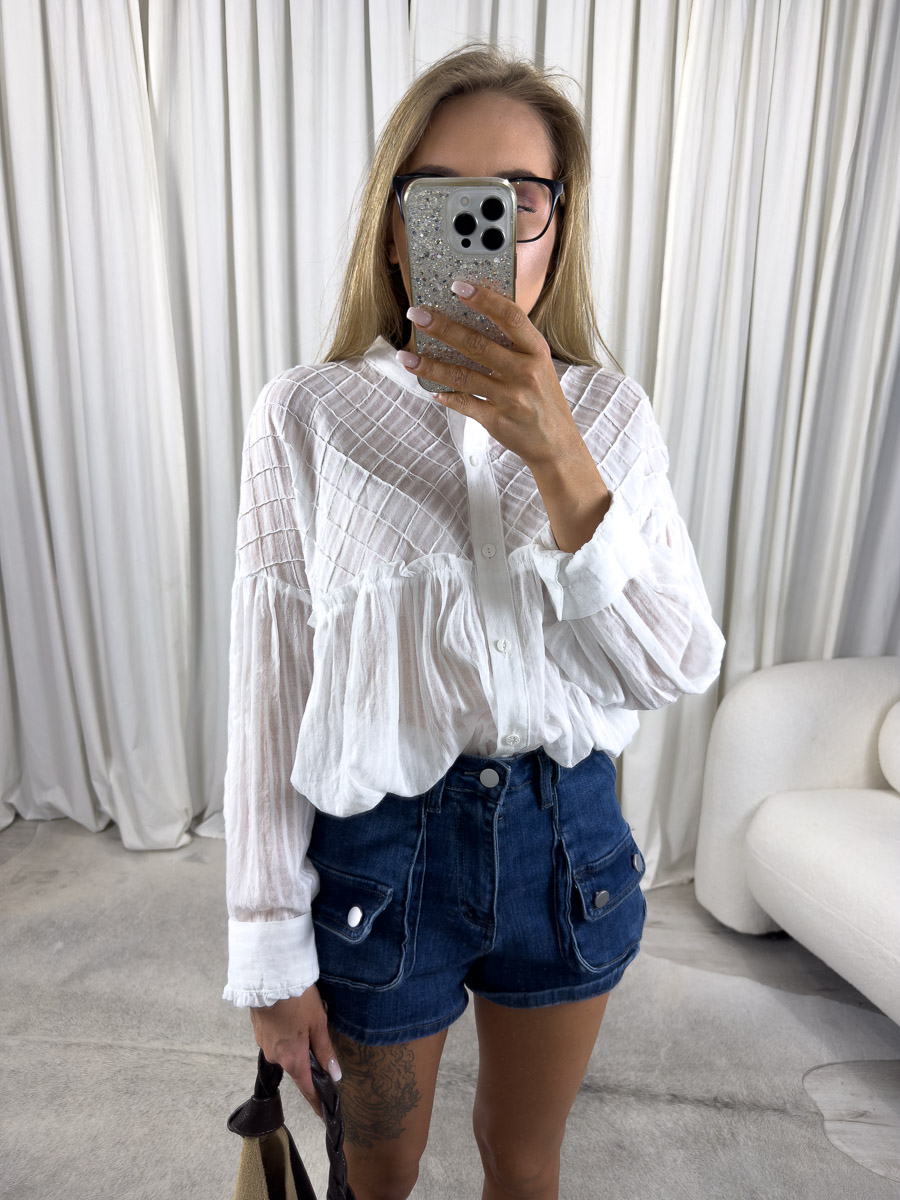 koszula-elle-wiya Koszula Elle Wiya – zdjęcie produktowe sklepu internetowego z odzieżą damską, prezentujące lekką, białą koszulę z bufkami i teksturą w stylizacji z szortami